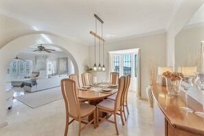 A dining area with a round table, chairs, and hanging light fixtures.
