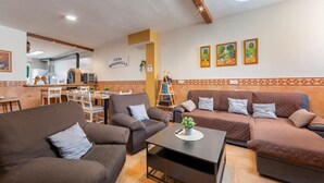Un salon confortable avec des canapés, une table basse et une cuisine en arrière-plan.