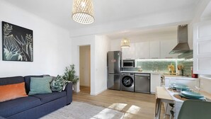 A modern kitchen with a refrigerator, microwave, and washing machine. - Apartment 'Jardim Da Parada' with Wi-Fi and Air Conditioning (Cascais)