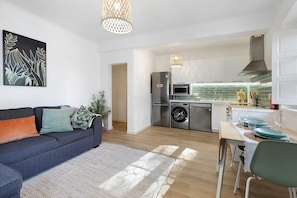 A modern kitchen with a refrigerator, microwave, and washing machine.