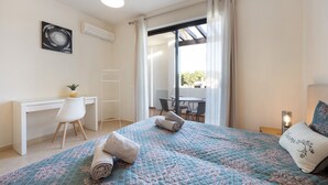A hotel room with a bed, a desk, a chair, a small table, and a window with curtains. - Apartment 'Duo Village' with Shared Pool, Wi-Fi and Air Conditioning (Alvor)