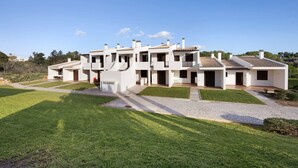 A modern multi-story residential building with a spacious courtyard, multiple balconies, and a clear sky. - Apartment 'Duo Village' with Shared Pool, Wi-Fi and Air Conditioning (Alvor)