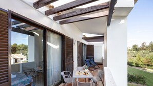 A modern outdoor patio with a table, chairs, and a small seating area. - Apartment 'Duo Village' with Shared Pool, Wi-Fi and Air Conditioning (Alvor)