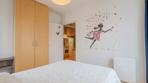 Ein Schlafzimmer mit Bett, Kleiderschrank und Wandbild.
