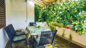 A patio with a table set for two, chairs, and a wall of greenery. - 1 bedroom lovely apartment in Split (Split)