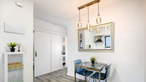 A modern kitchen with a glass dining table, blue chairs, and pendant lighting. - Vacation Apartment 'Eras Views' with Sea View and Wi-Fi (Las eras)