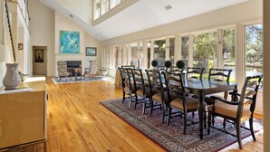 A spacious dining area with a high ceiling, large windows, and a view of the outdoors. - Monthly Stays Available! Pool/WalkToBeach/1MileToSaltyDog/LagoonSetting/Relaxing (Hilton Head Island)