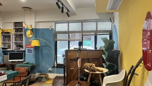 A room with a wooden desk, a chair, a computer, a lamp, and a window with blinds. - enjoy youth hotel (Wuhan)
