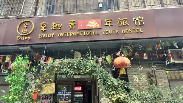 A building with a sign that reads "Enjoy International Youth Hostel". - enjoy youth hotel (Wuhan)