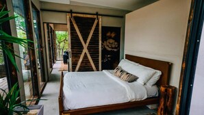 Un dormitorio con una cama de madera, un ventanal y vistas al exterior.