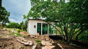 Un pequeño edificio moderno con un sendero de piedra que conduce a una puerta de cristal.