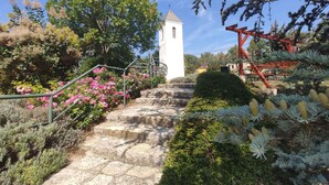 A stone staircase leading to a white tower with a red structure nearby. - Studio with large terrace and mountain view (Csopak)