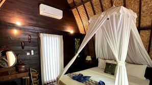 Un dormitorio con cama con dosel, muebles de madera y techo rústico.