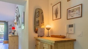 Un mueble de madera con un espejo, una lámpara y cuadros enmarcados en la pared.