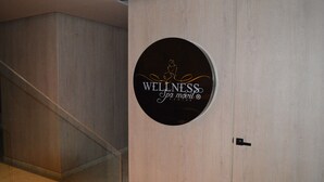 A circular sign with the text "WELLNESS Spa Mobil Center" on a light-colored wall. - Luxury Smart Loft in Bogota Chico , GYM POOL AND SPA  (Bogotá)