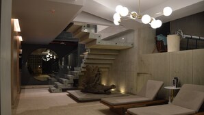 A modern interior with a staircase, lounge chairs, and a unique light fixture. - Luxury Smart Loft in Bogota Chico , GYM POOL AND SPA  (Bogotá)