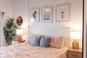 Cozy retreat with a large bed, bedside tables, and a potted plant.
