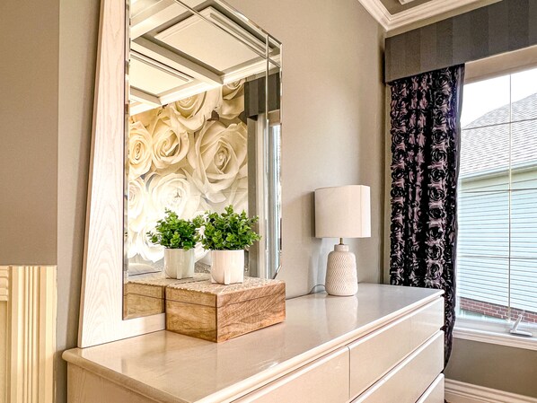 Reflect on your beauty in the spacious bathroom, featuring a large mirror, decorative wall, and elegant touches.