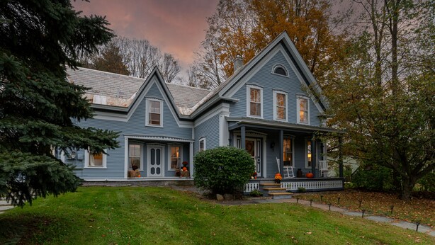 A two-story house with a porch, a small garden, and a well-maintained lawn. - Historic 150-year-old farmhouse, Jacuzzi included (Chester)