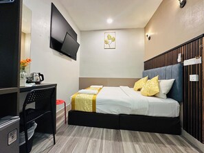 A hotel room with a bed, a desk, a chair, a television, and a wall-mounted artwork. - SS GREY HOTEL  (Kuala Lumpur)