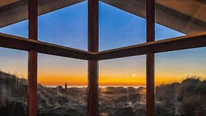 A room with a large window offering a view of a sunset over a hilly landscape. - Beautiful home in Saltum (Saltum)