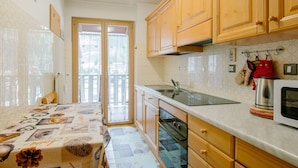 A kitchen with wooden cabinets, a stainless steel sink, and a microwave. - Lovely apartment for 5 guests with WIFI, TV and balcony (Canazei)