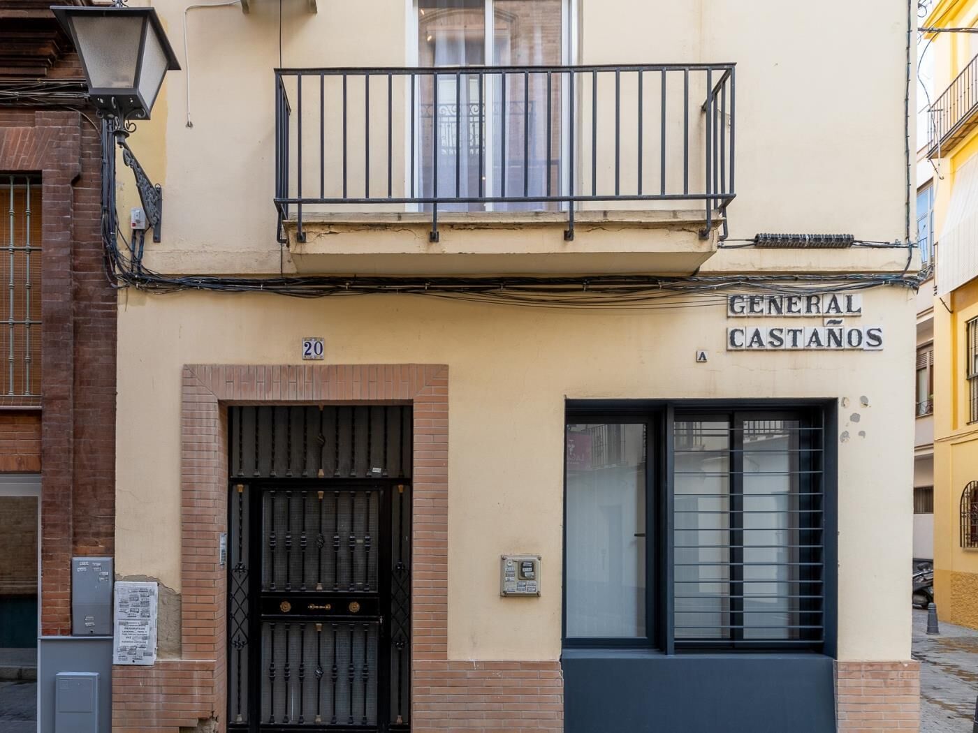 Un edificio con un cancello in metallo nero, un balcone e un cartello con su scritto "GENERAL CASTAÑOS".
