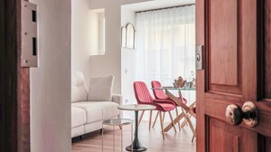 A modern living room with a white sofa, a glass coffee table, and red chairs. - Pure Seville elegance and comfort (Sevilla)