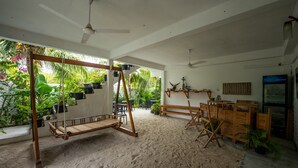 Una habitación con una mecedora, muebles de madera y vistas a un follaje exuberante.