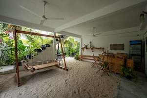 Una habitación con una mecedora, muebles de madera y vistas a un follaje exuberante.