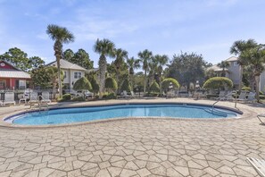 A swimming pool with a tiled deck, surrounded by palm trees and lounge chairs. - Golf Cart and 4 Bikes! Walk and Bike to the Beach or Gulf Place! Access 2 Pools! ~ Pineapple Under the Sea on 30A (Santa Rosa Beach)
