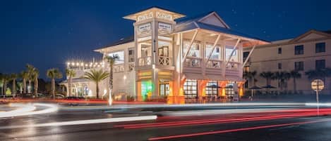 Un hotel de varios pisos con una torre destacada y balcones, que presenta un diseño arquitectónico moderno.