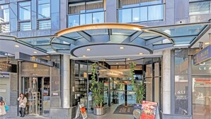 La entrada de un edificio moderno con una cubierta de vidrio, con letreros que indican 'Mantra Sydney Central' y 'Fortune Abalone Australia'.