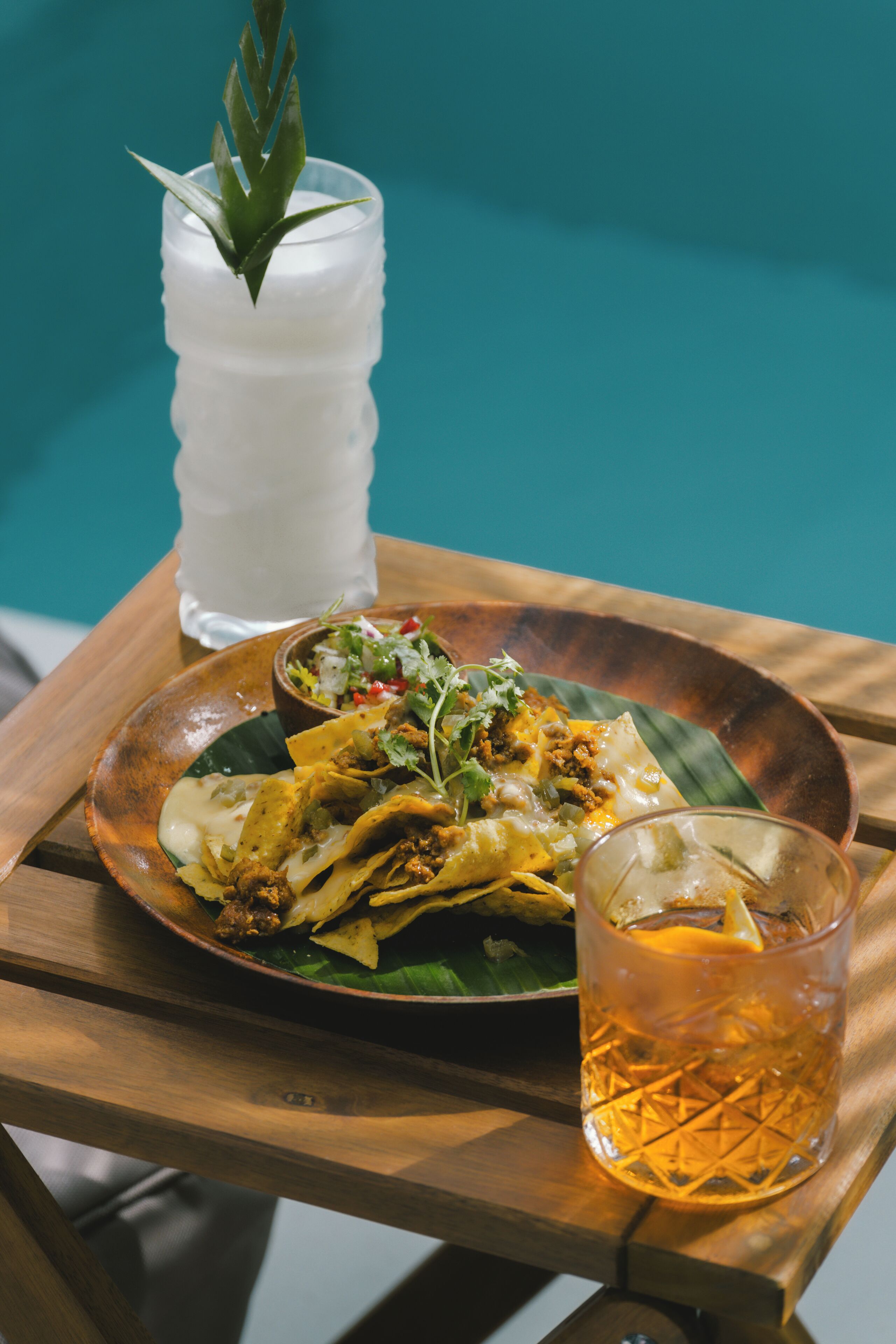 Una mesa de madera con un plato de comida y un vaso de bebida.