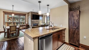 A modern kitchen with granite countertops, a dishwasher, and a stone backsplash. - Air Conditioning-Heated Pool-3 Hot Tubs-Gym-Garage-Game Room-Elevator-FirePit-Grill-W/D in Unit-Deck (Steamboat Springs)