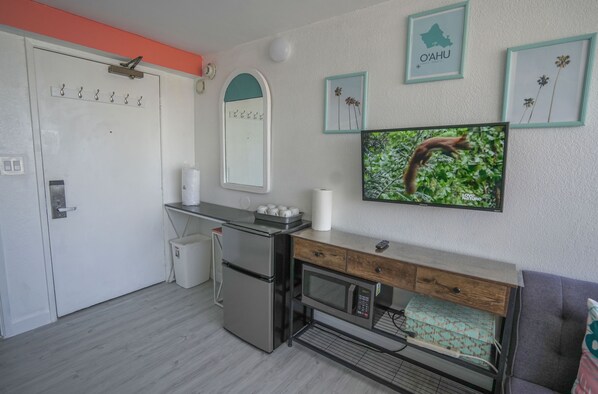 A compact kitchenette with a refrigerator, microwave, and a small countertop.