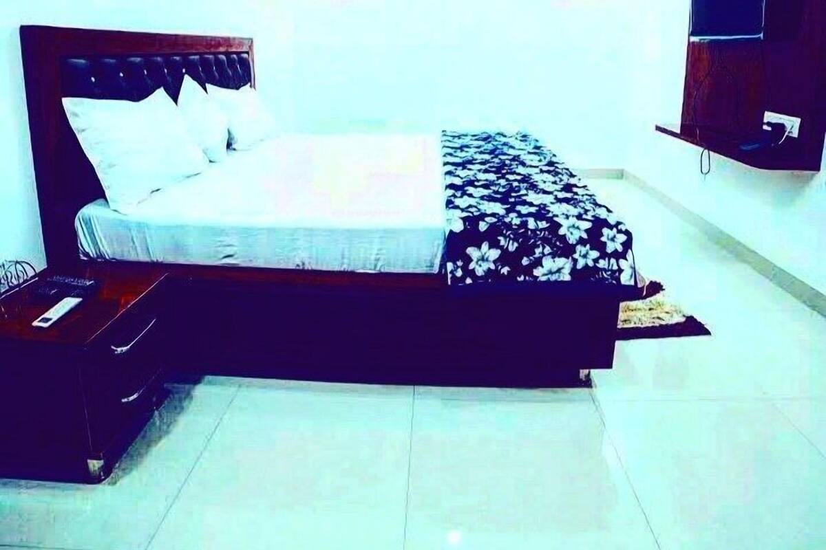 A bedroom with a bed, a TV, and a nightstand.