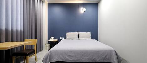 Una habitación de hotel moderna con una cama, un escritorio y una silla.