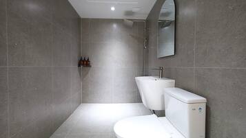 Een moderne badkamer met toilet, hygiëneschuimer en douche.