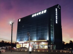 Ein modernes Gebäude mit Glasfassade und beleuchteter Beschilderung.