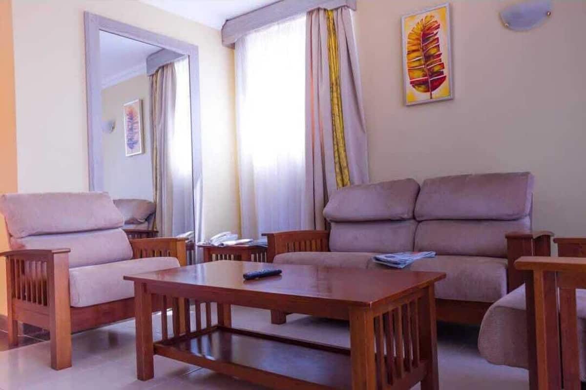 Una sala de estar con un sofá, sillones y una mesa de centro de madera.