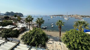 A marina with boats, palm trees, and a large cruise ship docked. - Gözegir Hotel - Adults Only (Bodrum)