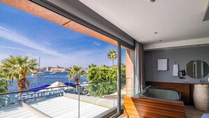 A modern hotel room with a balcony overlooking a marina and a cityscape. - Gözegir Hotel - Adults Only (Bodrum)