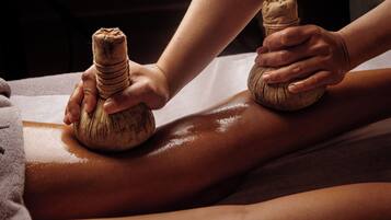 Eine Massageanwendung, wobei die Hände des Therapeuten und das Bein des Klienten im Fokus liegen.