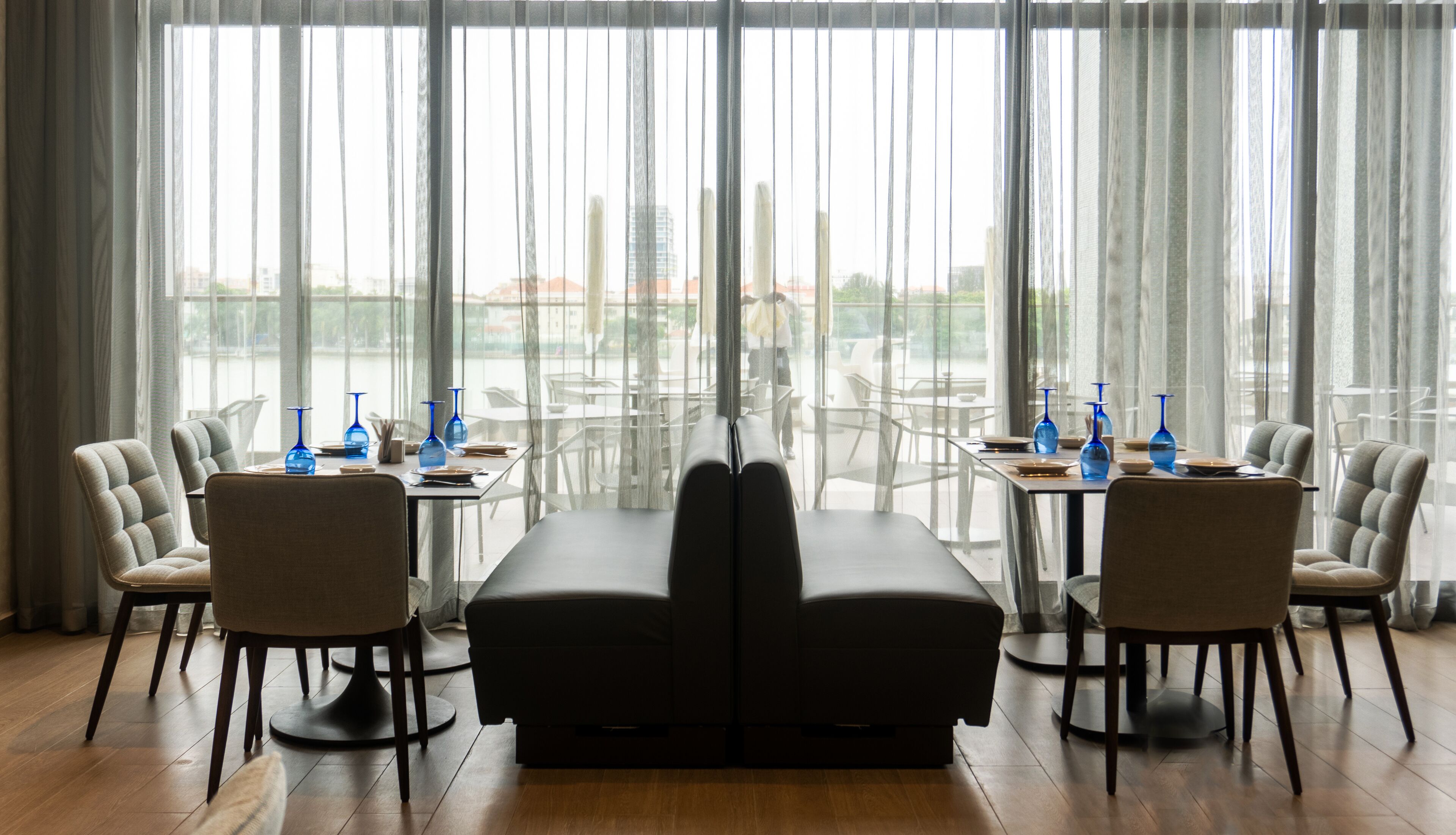 A dining area with a long table, two sofas, and six chairs.