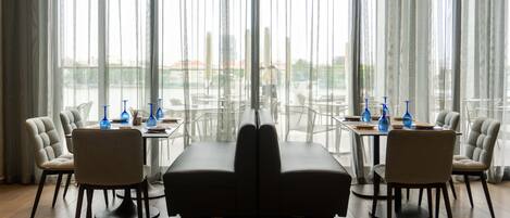 A dining area with a long table, two sofas, and six chairs.