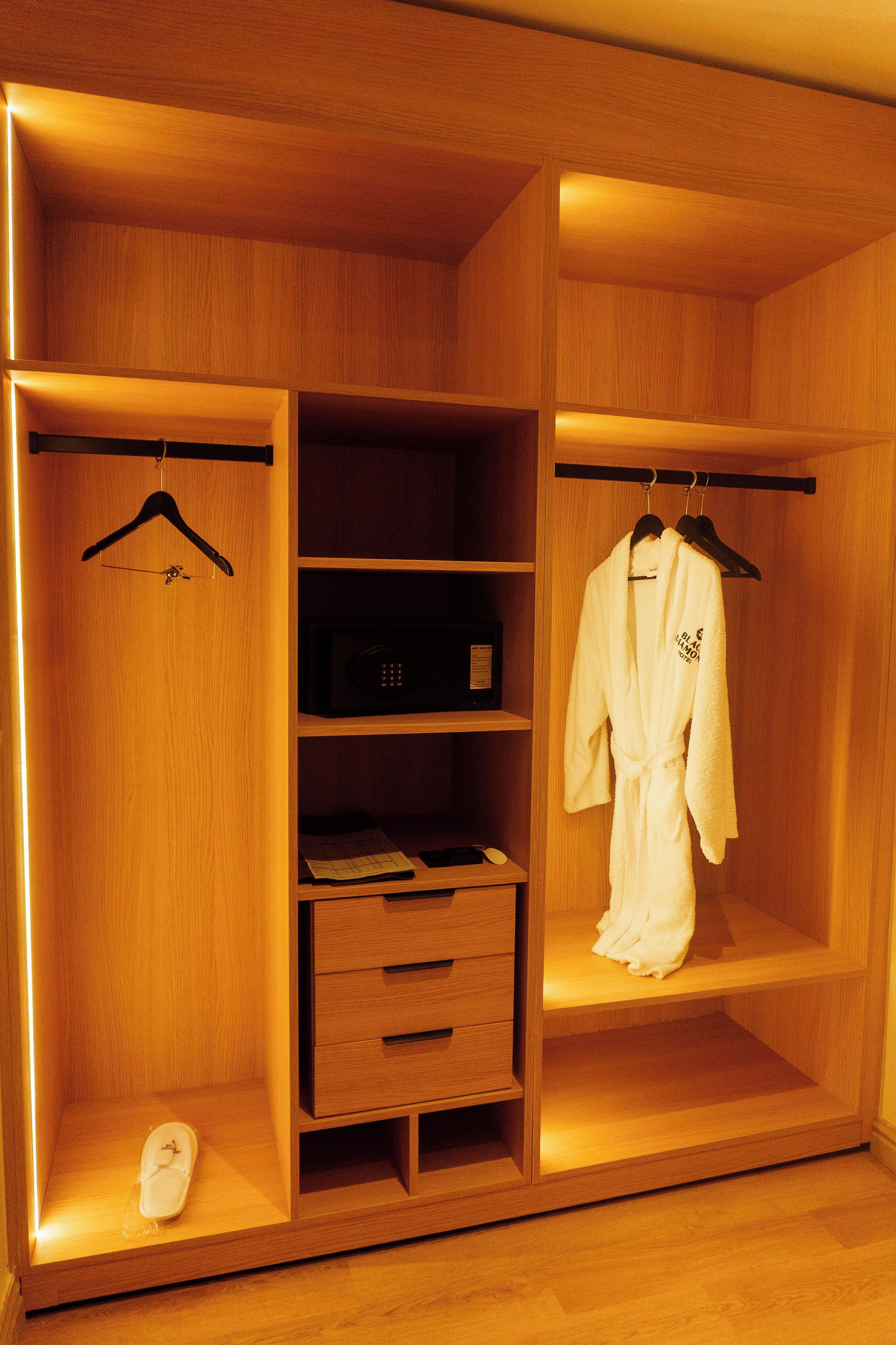 A wooden wardrobe with multiple shelves, a hanging rack, and a shoe rack.