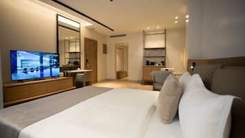 Una habitación de hotel moderna con una cama grande, un televisor, un escritorio y un espejo.