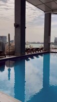 Una piscina al aire libre, sillones reclinables de piscina