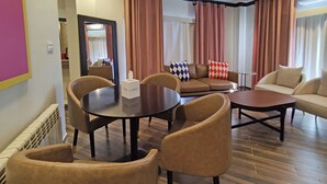 Een moderne woonkamer met een ronde tafel, twee banken en een salontafel.